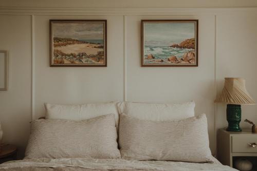 a bedroom with two pictures on the wall above a bed at Quaint and intimate 1-bed seaside cottage in Bridport