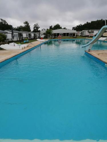 a swimming pool with a slide in the middle at Bungalow Martins Nazaré Land`s Hause in Pataias