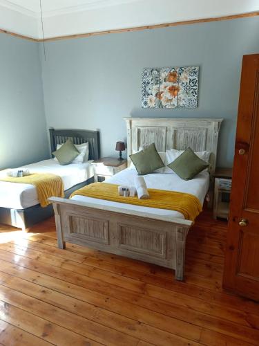 two beds in a room with wooden floors at Picanha Guesthouse in Heidelberg