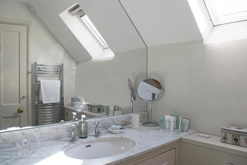 a bathroom with a sink and a mirror at Bookers Cottage in Bruern