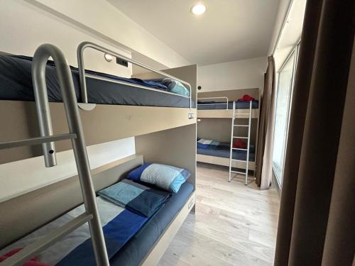 a room with two bunk beds and a hallway at Hostelum in Umag