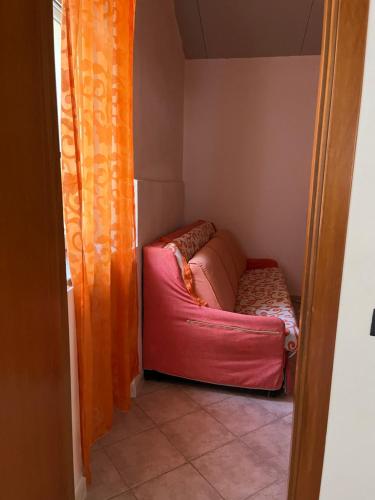a small room with a pink couch in the corner at Casa vacanze Alfano in Ascea