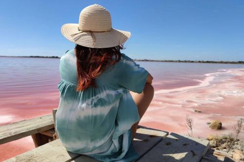 une femme assise sur un quai qui regarde l'eau dans l'établissement Les Ateliers Arles Centre, à Arles