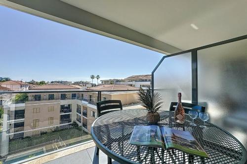 - une table sur un balcon avec vue sur un bâtiment dans l'établissement Le Secret Garden - 3-room apartment with pool - Palm beach, à Cannes
