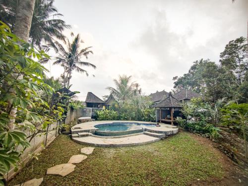 a backyard with a swimming pool and a house at Tangkas wooden house in Tampaksiring