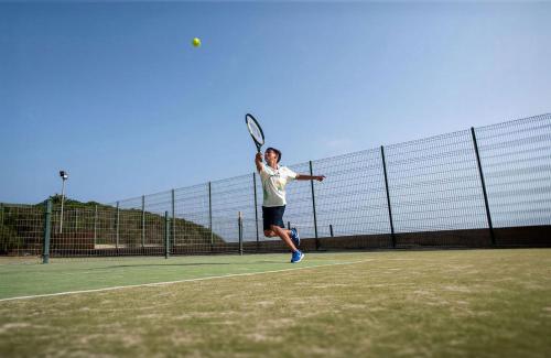 a man holding a tennis racket on a tennis court at Impressive Playa Granada Golf in Motril