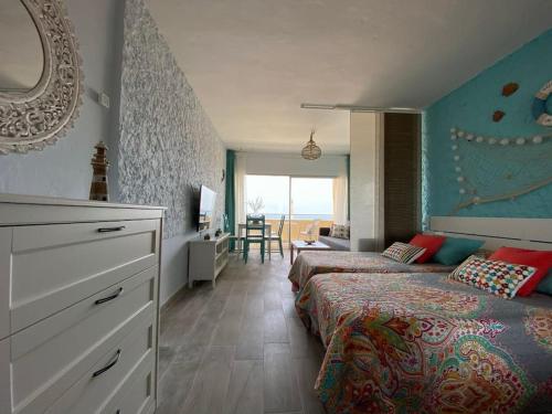 a bedroom with two beds and a living room with a window at Starfish Home, AWESOME VIEWS, FREE WIFI & NETFLIX in Morro del Jable