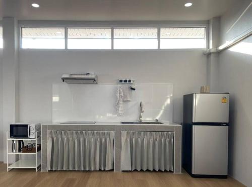 a kitchen with a refrigerator and a sink at Prod Place - Sunny Chiang Rai in Chiang Rai
