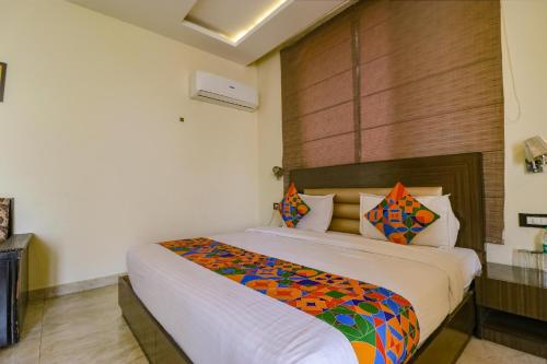 a bedroom with a large bed with a colorful blanket at FabHotel Narula in Dehradun