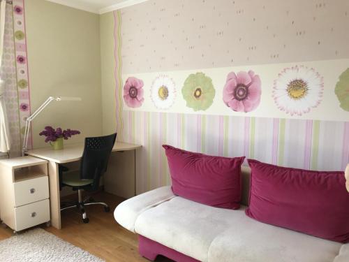 a bedroom with a bed with pink pillows and a desk at House on the sea side in Ragaciems
