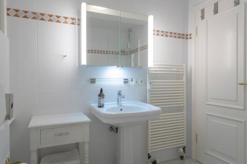 Un baño blanco con lavabo y espejo. en Deichgraf 3, en Kampen