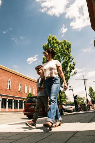 a man and a woman walking down the street at Hôtel Expérience - Quartier Des Marinas in Magog-Orford