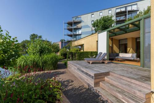 a house with a wooden deck with a bench at Villa Francine in Deinze