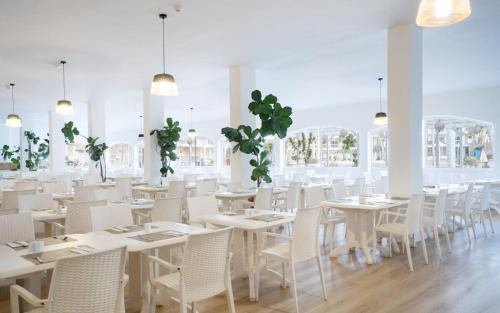a dining room with white tables and white chairs at Club Hotel Drago Park in Costa Calma