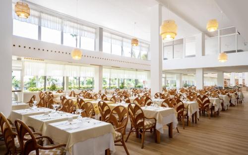 a large dining room with tables and chairs and windows at Club Hotel Drago Park in Costa Calma