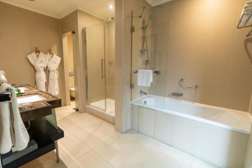 a bathroom with a tub and a shower and a sink at Sundance Hotel Istanbul in Istanbul