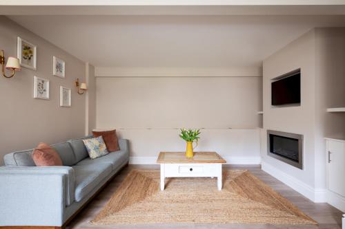 a living room with a couch and a table at Stable Cottage Chatsworth Estate in Baslow