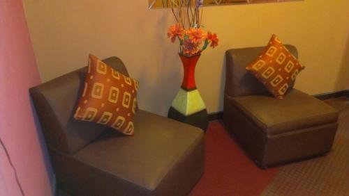 two chairs and a vase in a living room at Hostal GQ in Lima