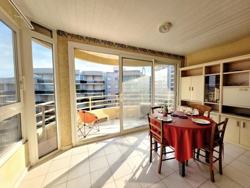 une salle à manger avec une table et un balcon dans l'établissement Canet-en-Roussillon T3 - 4 pers, CLIM, WIFI, PARKING, Loggia, 3 étoiles - FR-1-794-139, à Canet