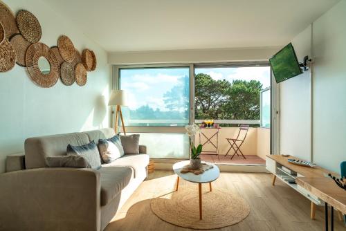 un salon avec un canapé et une table dans l'établissement Le Rocher de Bénodet - Studio 2p 150m de la plage, à Bénodet