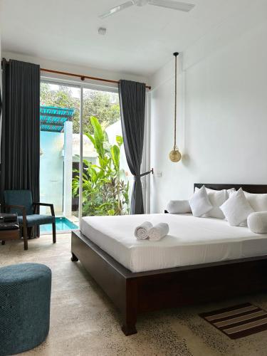 a bedroom with a bed and a large window at Private Pool Cabanas AC - Angam Villas Hikkaduwa in Hikkaduwa