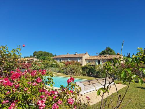 a garden with a bench and flowers in front of a house at Alpilles Cottage Philippe's Farm Gite 55m2 - 2 chambres - calme - piscine mas des figues - agritourisme bio - 3km Saint Rémy de Provence - Parc Naturel Régional des Alpilles - 6km Baux de Provence - in Saint-Rémy-de-Provence