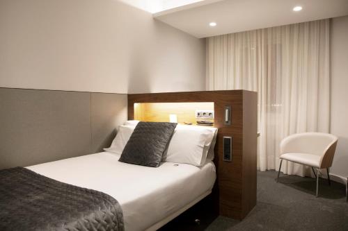 a hotel room with a bed and a chair at Best Western Premier Hotel Dante in Barcelona