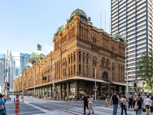 a large building with people walking in front of it at Holiday Home by Barangaroo Reserve in Sydney