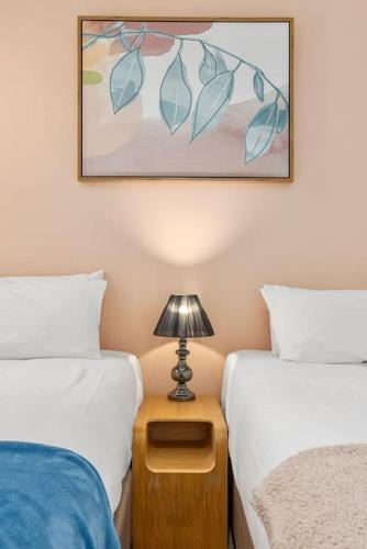 a bedroom with two beds and a lamp on a night stand at Holiday Home by Barangaroo Reserve in Sydney