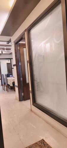 a large glass window in a room with a table at Hostmystay- 3bhk apartment!Greater kailash 1 in New Delhi