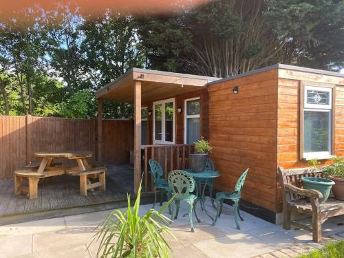 a small cabin with a picnic table and chairs at Bar Lodge in Ilkeston