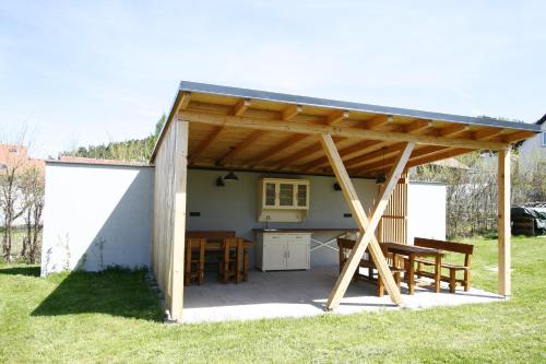 a pavilion with a table and benches in a yard at Červený Stylový Apartmán 3 km od Malé Skály in Koberovy