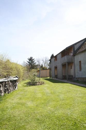 an empty yard next to a building with a stone wall at Červený Stylový Apartmán 3 km od Malé Skály in Koberovy