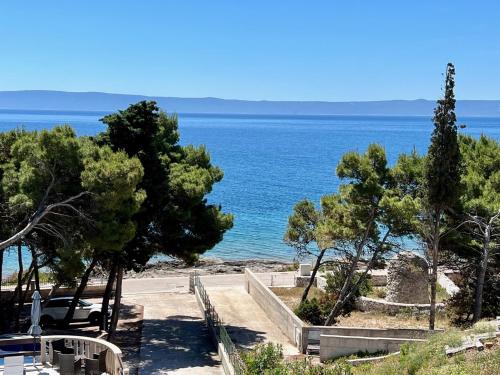 a view of the ocean from a hill with trees at Vila Vera Seafront Apartments in Sumartin