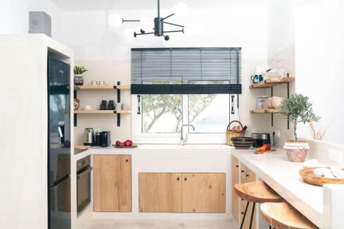 a kitchen with a window and a white counter at Thalassa in Ios Chora