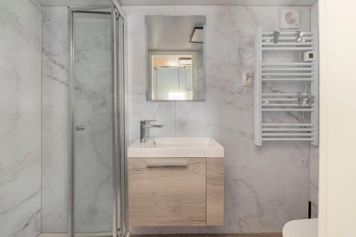 un bagno con lavandino e doccia in vetro di Tiny House Ljubljana a Lubiana