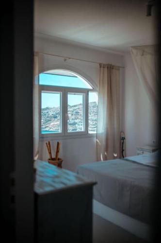 a bedroom with two beds and a window at Thalassa in Ios Chora