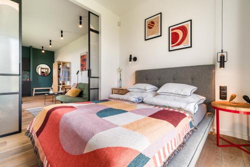 a bedroom with a bed with a colorful blanket at Luksusowy apartament Ryn Mazury Widok na Jezioro, Gorąca BALIA in Ryn