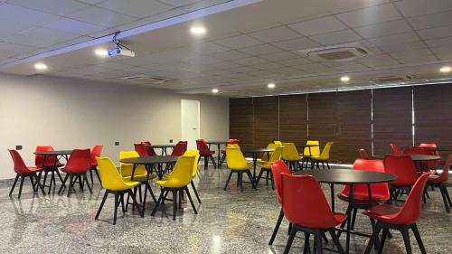a room with tables and chairs with yellow chairs at BluO 1BHK Suite - Balcony, Lift, Gym, Parking in Gurgaon