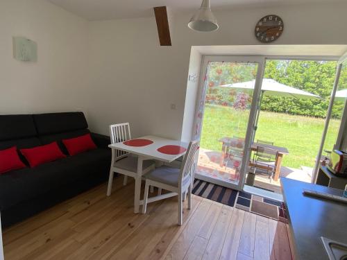 un salon avec une table et un canapé dans l'établissement Les gîtes de la Couleyre - Gîte Fraise des Bois - 2 personnes, à Lachapelle-Graillouze