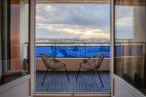 - deux chaises sur un balcon avec vue dans l'établissement Le Bella Carmen - Near Eurexpo & Groupama Stadium, à Saint-Priest