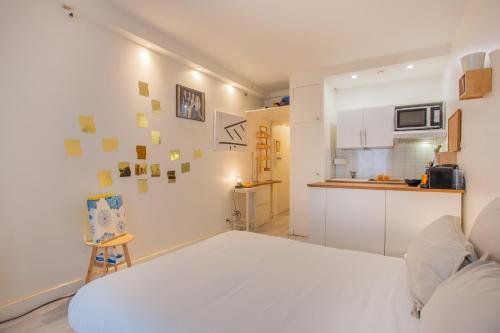 Cet appartement comprend une chambre avec un lit blanc et une cuisine. dans l'établissement Faiderbe-Chaligny-1-Bed Apt Sleeps 2, à Paris