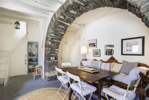 un soggiorno con un tavolo e un divano di Tinos experience the house a Panormos
