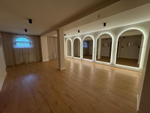 an empty room with a wooden floor and a large window at Dom Górski 878 mnpm in Zakopane