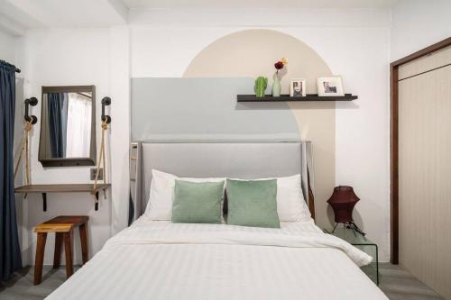 a bedroom with a white bed with green pillows at Cozy House Chatuchak market, 12pp in Bang Su