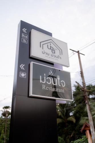 a sign for a hotel with two signs on it at น่าน ม่วนใจ Nan Muanjai Hotel in Pua