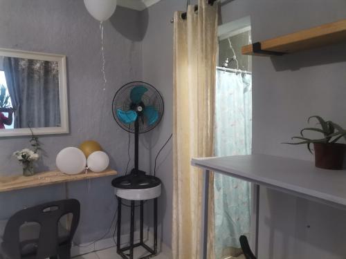 a kitchen with a fan in the corner of a room at Oceans Black in Durban