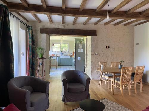 un salon avec une table et des chaises dans l'établissement Maison de la petite sorcière, à Razac-de-Saussignac