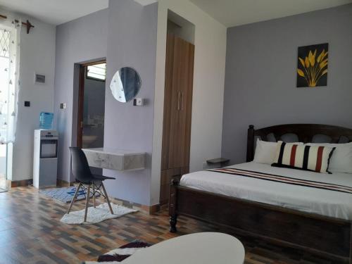 a bedroom with a bed and a desk and a chair at Kelly Homes in Kilifi