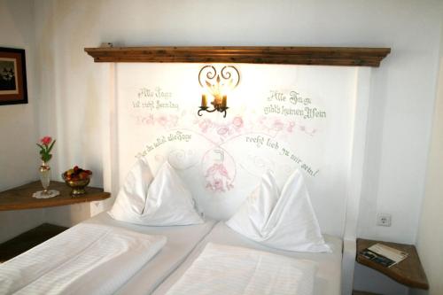 a bedroom with a bed with a wall with writing on it at Alp Art Hotel Götzens in Innsbruck